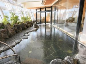 a pool of water in a building with rocks at City Plaza Osaka in Osaka