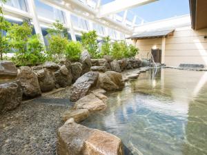 a pool of water with rocks in a building at City Plaza Osaka in Osaka