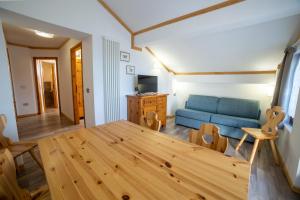 a living room with a table and a blue couch at Residence Derby Club in Folgaria
