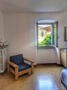 une chaise bleue dans une pièce avec une fenêtre dans l'établissement Casa Valle - Lago di Garda, à Brenzone