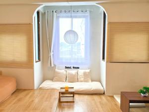 a living room with a couch in front of a window at Seoul House นครสวรรค์ in Sathani Pak Nam Pho