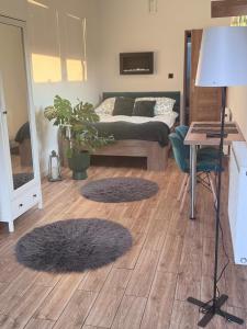 a bedroom with a bed and two rugs on the floor at Hostel Suchedniów in Suchedniów