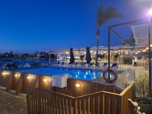 a swimming pool with chairs and a hotel at night at Sea Gull Marina Hotel in El Alamein