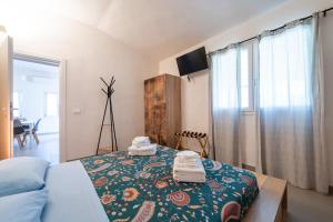 a bedroom with a bed with towels on it at Macondo Agriliving Apartments in Castiadas
