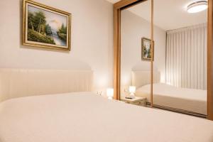 a bedroom with a white bed and a mirror at Caesarea Vacation Rooms in Caesarea