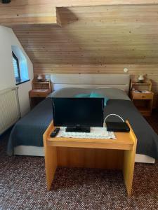 a bedroom with a bed with a desk with a computer on it at Apartment Cvetek Janez in Bohinj