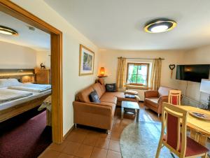 a hotel room with a bed and a living room at Ferienwohnung Jodlschmid in Ruhpolding