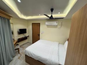 a bedroom with a white bed and a ceiling at Hotel Skyline in Janakpur