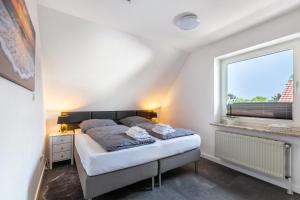 a bedroom with a bed and a window at Fewo Kleine Auszeit 100qm in Friedrichskoog