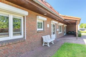 a bench sitting on the side of a brick house at Fewo Kleine Auszeit 100qm in Friedrichskoog