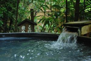a water fountain in the middle of a pool of water at Kyo no Minshuku Ohara no Sato in Kyoto