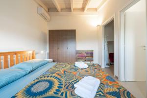 a bedroom with a large bed with towels on it at Macondo Agriliving Apartments in Castiadas +49 photos