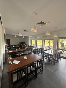 a restaurant with wooden tables and chairs and windows at U Górala in Cieszków