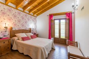 a bedroom with a large bed with pink curtains at La Cabaña de Manuela in Bustantegua
