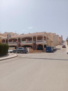 a large building with cars parked in a parking lot at Sol y playa in Palomares
