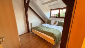 a small bed in a small room with a window at Apartmány v Žitě in Třeboň
