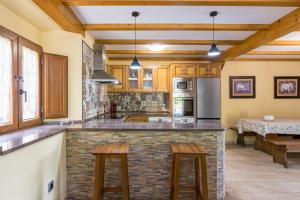 a kitchen with a stone counter top and wooden cabinets at La Cabaña de Manuela in Bustantegua