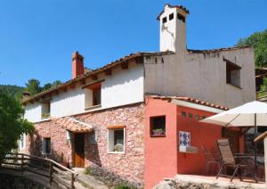 an old building with a table and chairs outside at Puerta Partida, vivienda rural en Lugar La Peruela, Jaén in Pontones