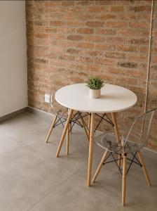 a white table with a potted plant on it next to a brick wall at Staynrestapartment in Nelspruit