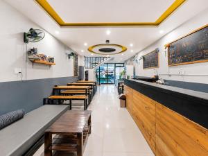 a restaurant with wooden benches and a bar at Two Horses Hostel in Hoi An