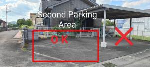 a parking lot in front of a building with a sign at 海っぺり宮崎 in Miyazaki