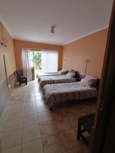 ein Schlafzimmer mit zwei Betten und einem Fenster in der Unterkunft Skippers Backpackers CC in Walvis Bay