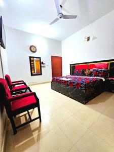 a bedroom with a large bed and a chair at Royal Villa in Karachi