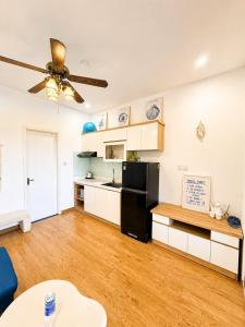 a living room with a black refrigerator and a table at Arrive Hotel & Apartment in Danang