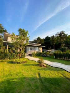 a house with a gravel driveway in front of a yard at Hornbill Pool Villas 1 in Ko Chang