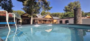 a large swimming pool in front of a house at Las Cabañas del Bosque in Chiva