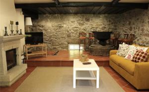 a living room with a couch and a fireplace at Casa Moinho da Levada - Refúgio à beira do rio Coura in Paredes de Coura