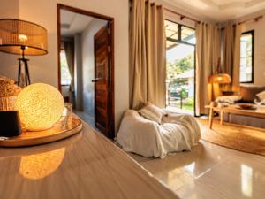 a living room with a table with a lamp and a couch at Casa Eden - Double King Bed - Peaceful Garden Retreat - 4K SmartTV in Thong Sala