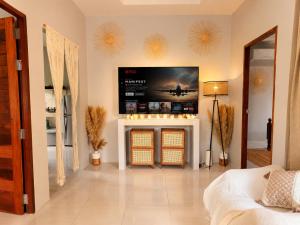 a living room with a fireplace with a tv on the wall at Casa Eden - Double King Bed - Peaceful Garden Retreat - 4K SmartTV in Thong Sala
