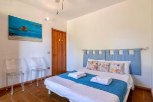 a bedroom with a large bed with two chairs at Casa 2 Punta Negra Vista Mare in Stintino