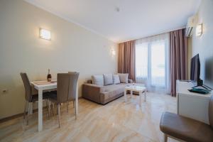 a living room with a couch and a table at Seafront Apartment with Panoramic Terrace in Golden Sands