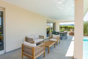 a patio with chairs and a table and a pool at Villa Hestia in Goudargues