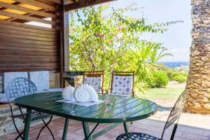 a green table and chairs on a patio at Casa 2 Punta Negra Vista Mare in Stintino