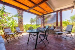 a patio with a table and chairs and a couch at Casa 2 Punta Negra Vista Mare in Stintino
