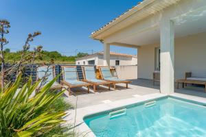 a patio with two chairs and a swimming pool at Villa Hestia in Goudargues