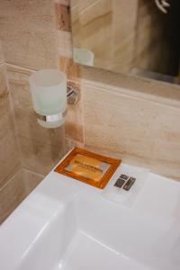 a bathroom sink with a soap dispenser on top of it at Seafront Apartment with Panoramic Terrace in Golden Sands +32 photos