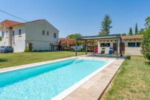 a swimming pool in a yard next to a house at Studio piscine Alpilles in Noves