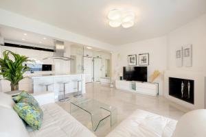 a living room with a white couch and a glass table at Ciel Collection - Luxury Seafront Living in Perea
