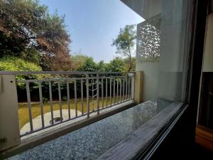 a balcony with a bench and a view of a yard at Arch Place in Gurgaon