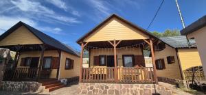 a couple of wooden houses with a porch at Las Cabañas del Bosque in Chiva +22 photos