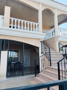 a building with a staircase leading to a balcony at Sol y playa in Palomares +6 photos
