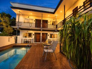 a patio with a table and chairs next to a pool at Nangkam Boutique Donsak in Ban Pheng Krong