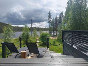 two chairs on a wooden deck with a view of a lake at Ruska in Syöte