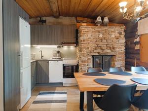 a kitchen with a table and a stone wall at Ruska in Syöte