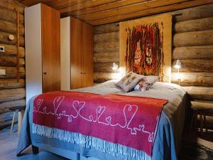 a woman laying on a bed in a log cabin at Ruska in Syöte