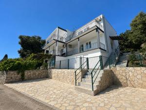 a large white house on top of a stone wall at CERES APARTMENTS free parking, kitchen & wi-fi in Utjeha